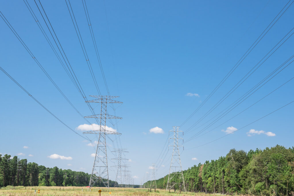 Blue sky day with transmission cooridor at the center of the photo.